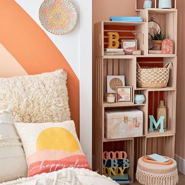 bookcase with summer décor next to bed in tan and pink shades